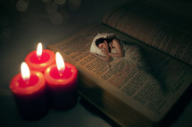 Candles lighting a woman sleeping on a bed superimposed on a Bible.