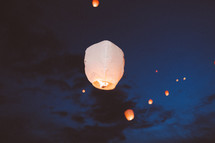 paper lanterns floating in the night sky