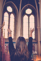 woman with raised hands in worship in a church 