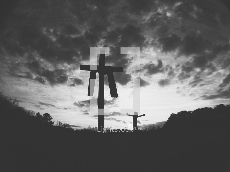 silhouette of a cross with shroud and woman with open arms 