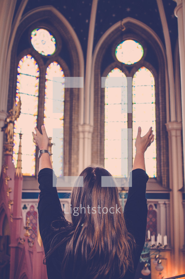 woman with raised hands in worship in a church 