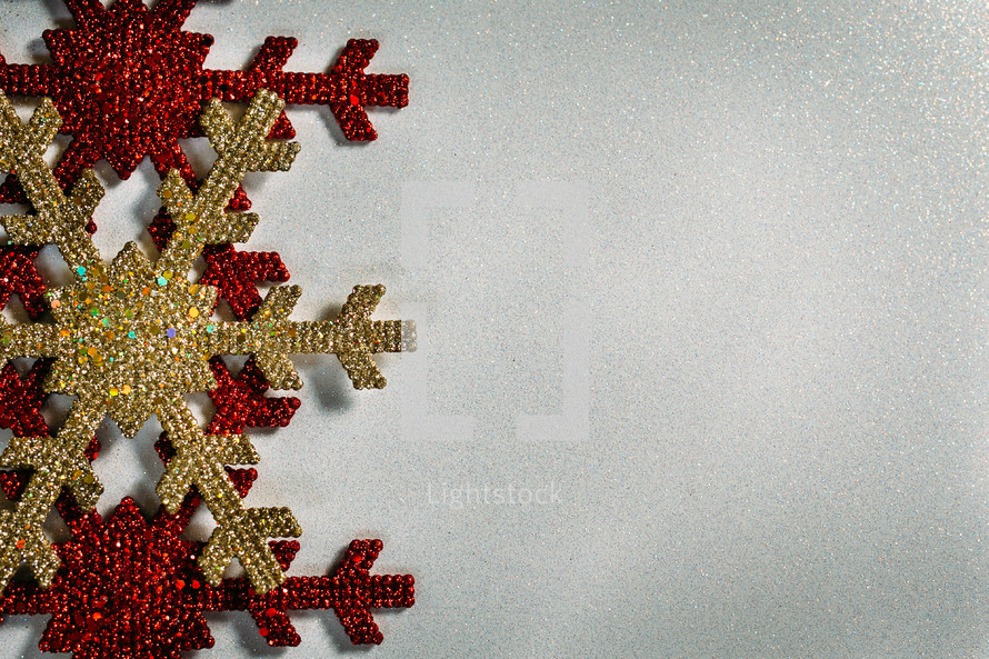 red and gold Christmas snowflake ornaments on a white background 