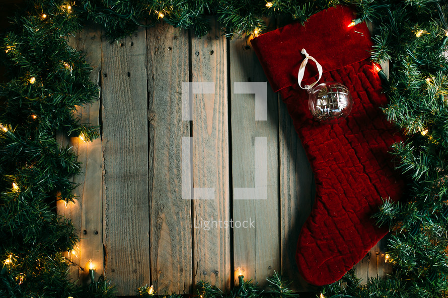Christmas lights and pine garland frame with stocking 