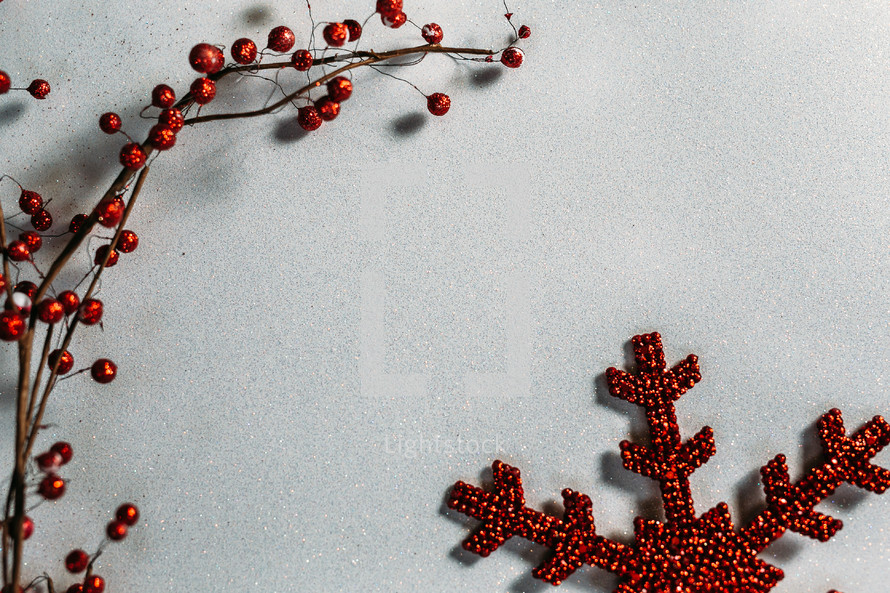 red berries and snowflake ornaments on a white background 