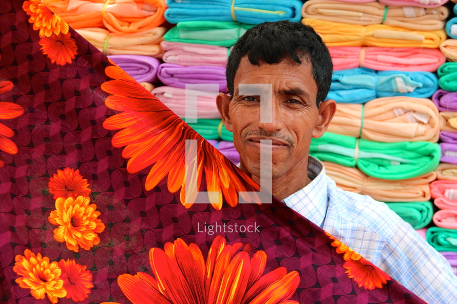 man folding fabric in the market 