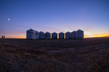group of silo's on a farm at sunset 