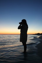 silhouette of a woman taking a picture 