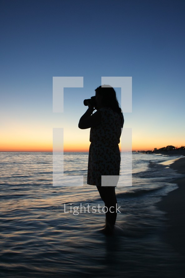 silhouette of a woman taking a picture 