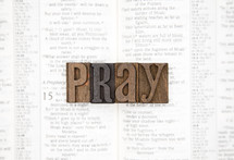 word pray on the pages of a Bible 