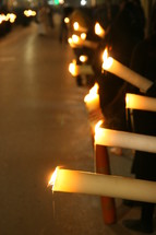 procession of people carrying candles 