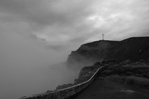 cross on a mountain peak and fog 