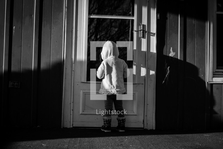 a child standing at a front door 
