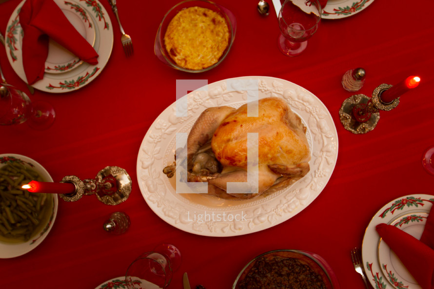 turkey on a platter in the center of a set table 