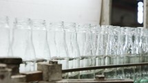Glass bottles production. Glass bottles on a conveyor belt in an industrial glass production facility