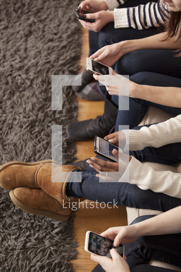 Teen girls looking at their cellphones. 