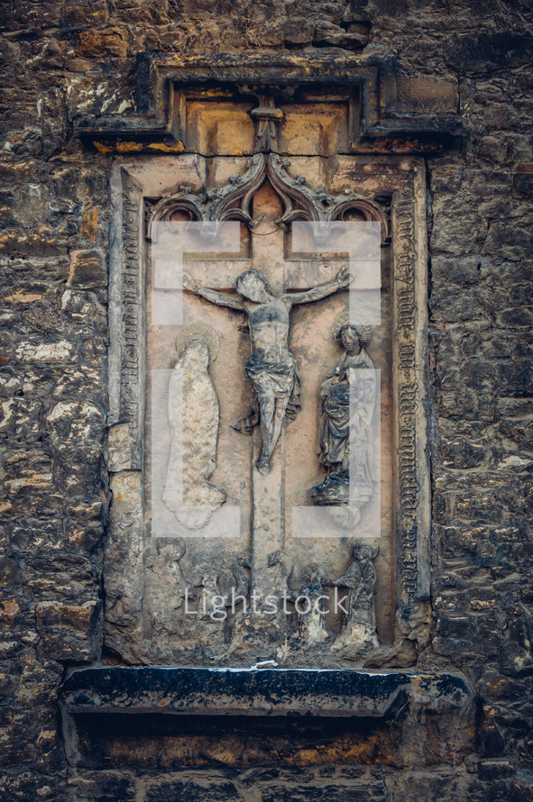 crucifix on the side of an old church 