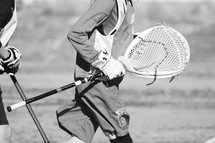 goalie carrying his stick on a boys Lacrosse team 