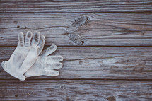 Work gloves laying on rustic boards.