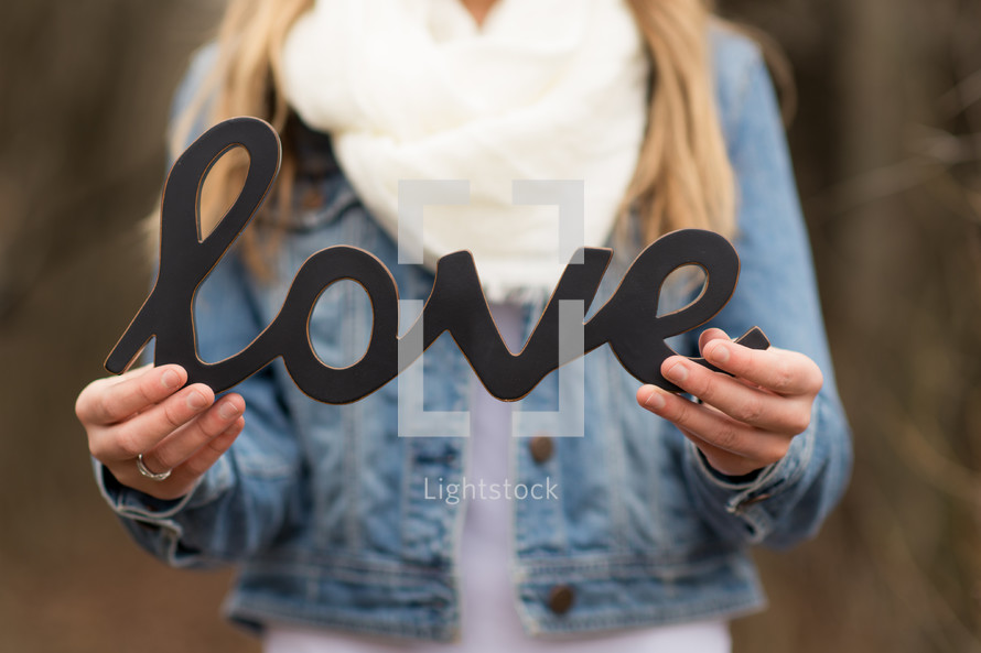 woman holding a sign of the word love 