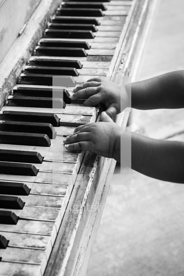 infant hands on an old piano 