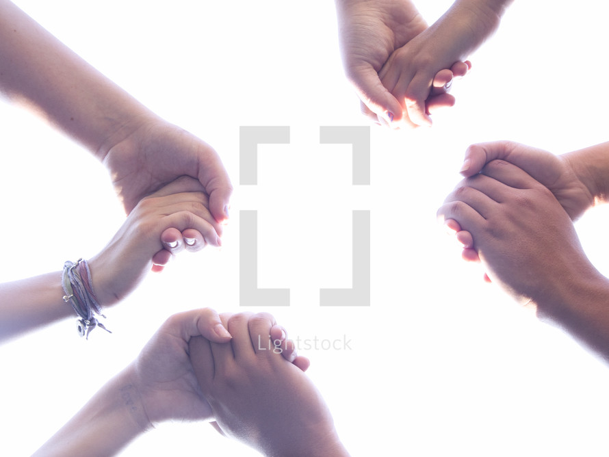 Group of People Praying in a Circle Holding Hands