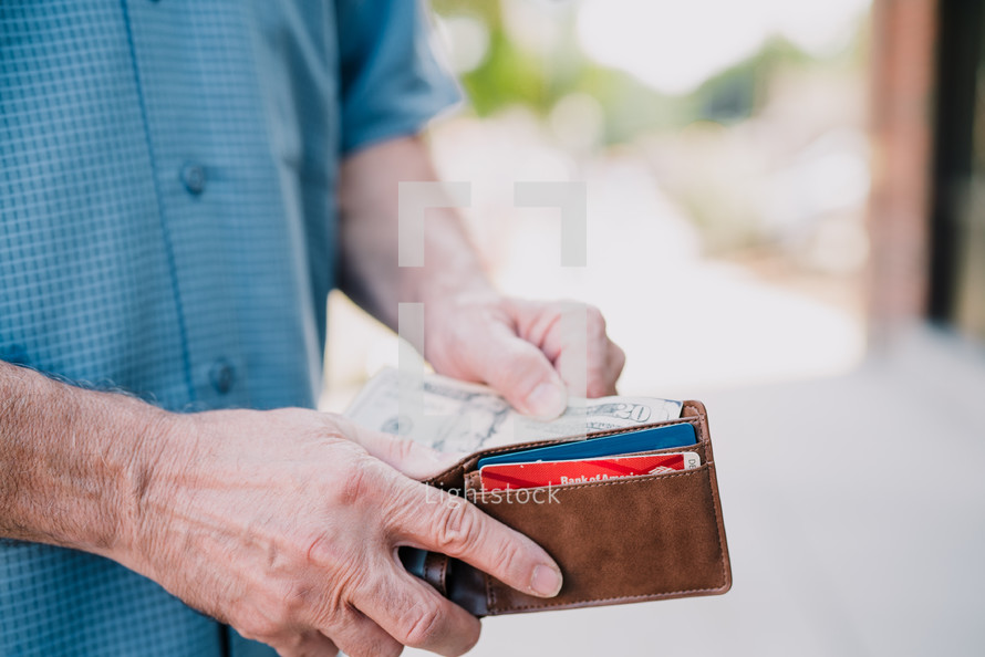 a man pulling cash out of his wallet 