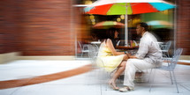 Couple eating lunch under table umbrella