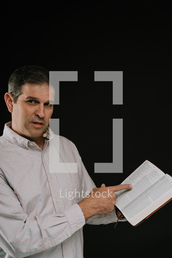 man reading from a Bible 