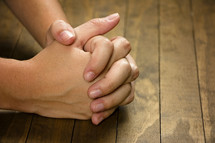 Praying with a wooden background