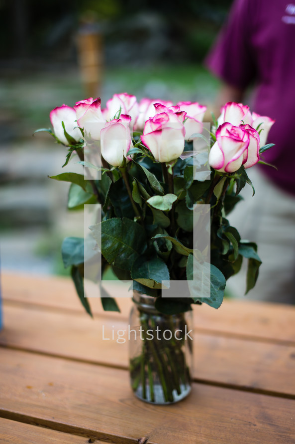 Bouquet of roses on a wooden table.