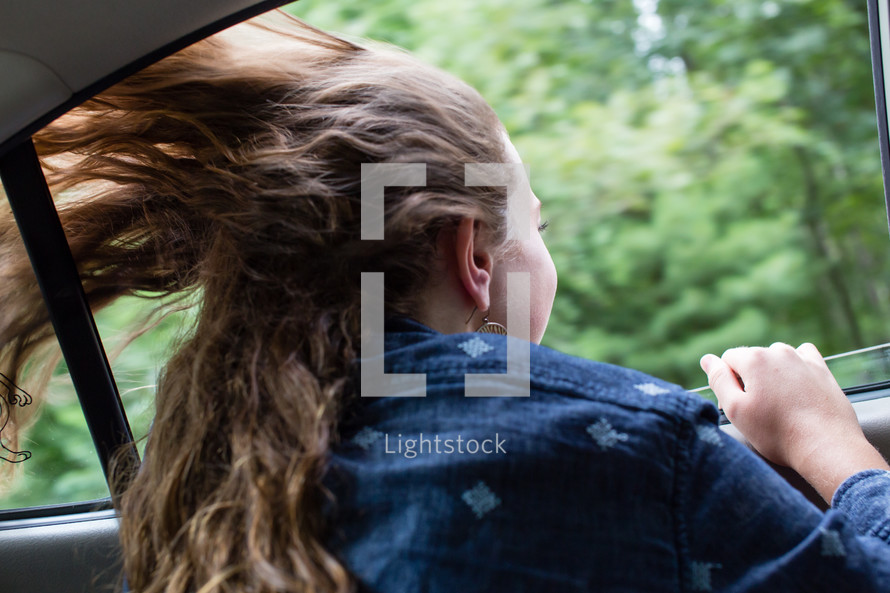 Girls' hair blowing in the wind while riding in... — Photo — Lightstock
