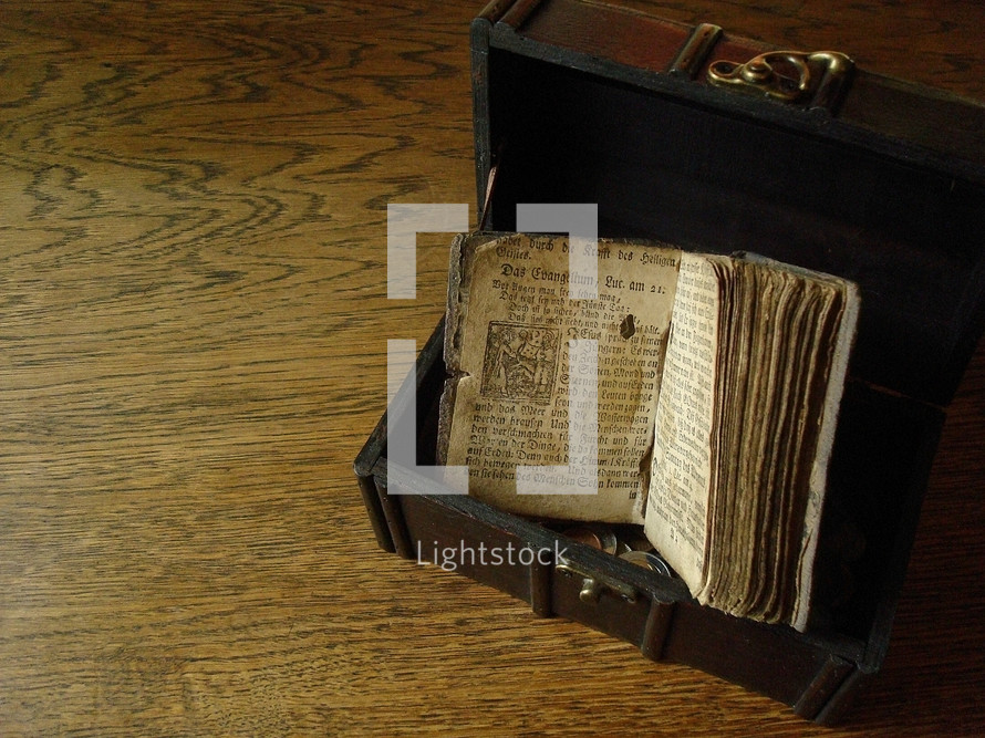 Ancient prayer book from Martin Luther in a treasure chest on a wood floor.