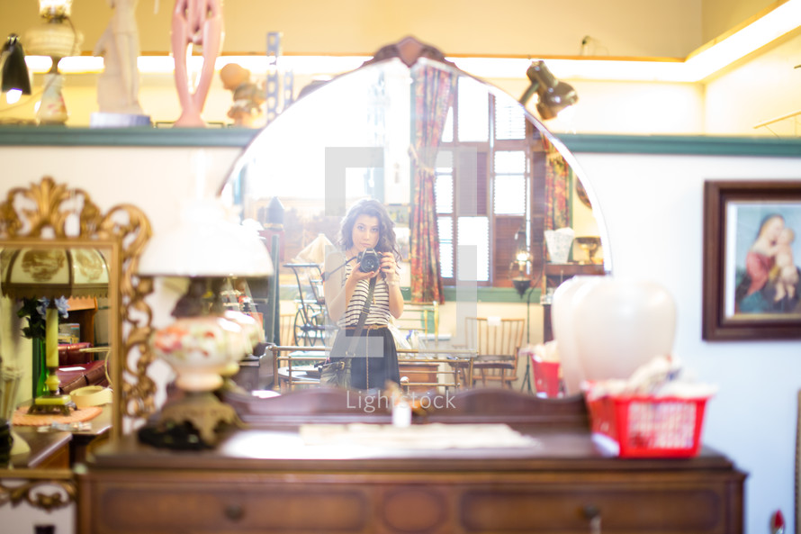 Woman taking a photograph in an antique shopl