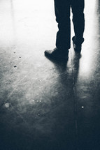 legs of man standing on concrete floor