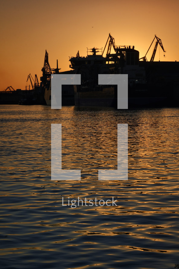 ships at a port harbor at sunset 