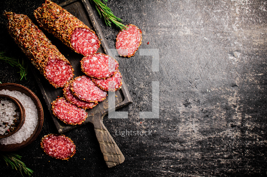 Delicious salami sausage on the table. On a black background. High quality photo