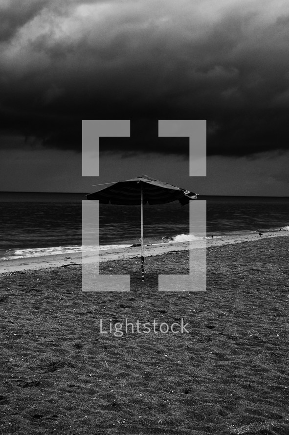 beach umbrella in the sand under a stormy sky