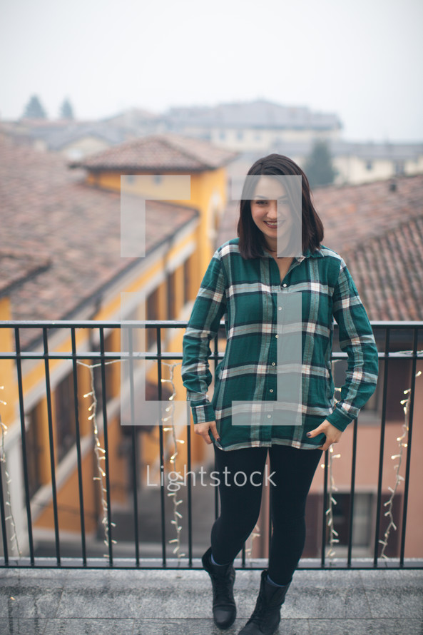 A woman in a green shirt smiling on a patio