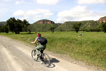 a man riding a bike on a dirt road 