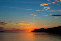 calm water along a shore at sunset 