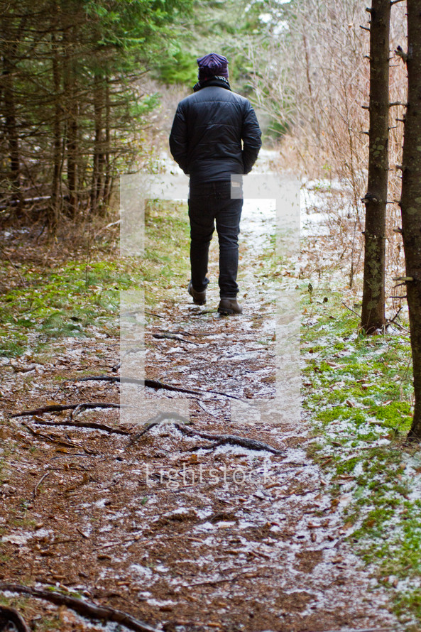Walking on a dirt trail through the forest after the snowfall.