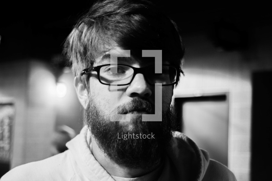 headshot of a man with a thick beard and glasses 