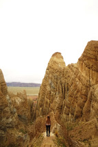 a woman standing on jagged peaks 