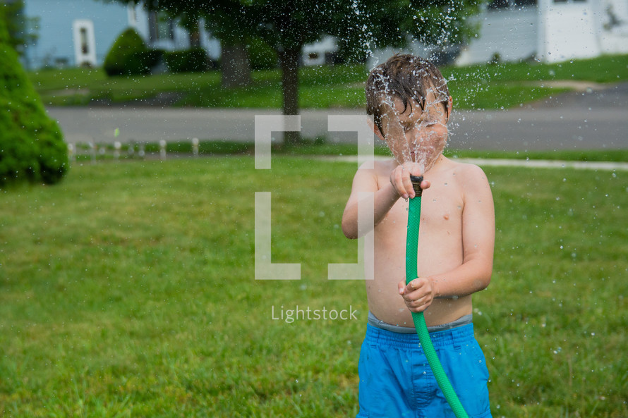a child holding a hose 