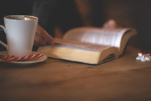 a man with a peppermint latte reading a Bible 