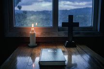 Bible with candlelight and cross

