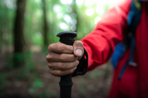 Close up hand of hiker man with hiking equipment walking in forest