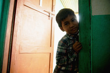 a child peeking in a cracked door 