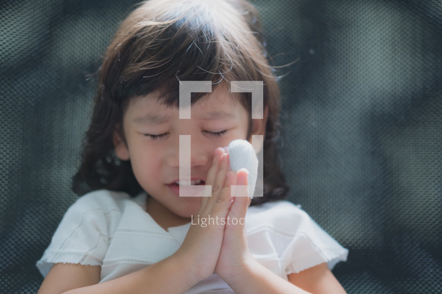 girl praying with a hurt hand 