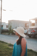 a woman standing outdoors in a sunhat 